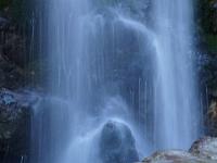 Nasser Fels vor Wasserfallschleier
